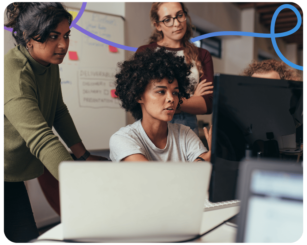 Image of female colleagues working at a desktop talking