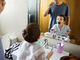 Father teaching the son how to brush