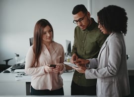 Group of multiethnic young concentrated businesspeople using digital tablet