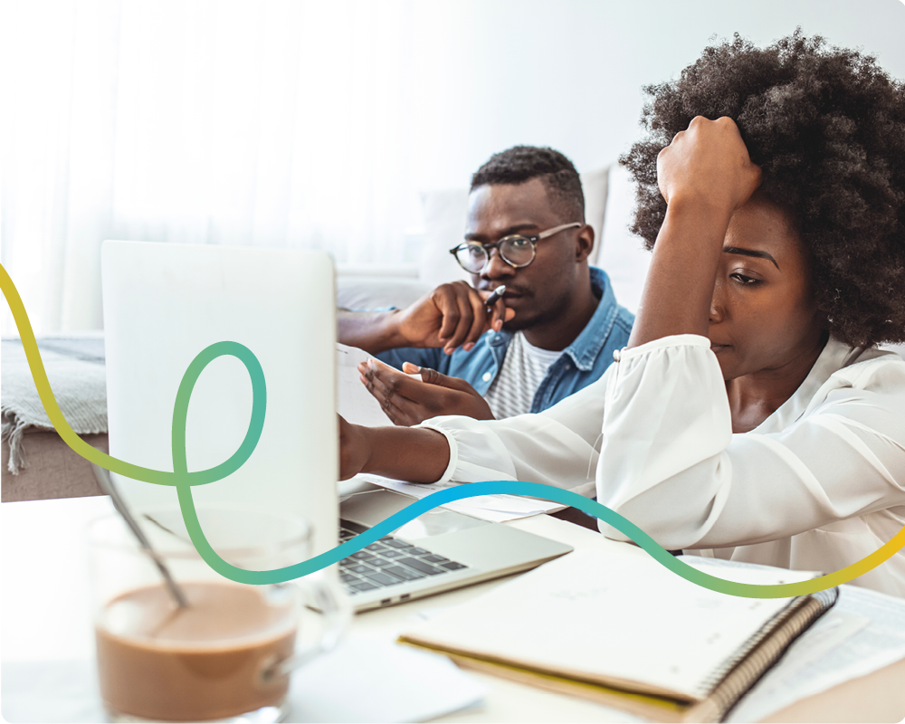 Image of a woman and a man looking at their laptop stressed.