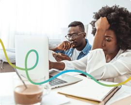 Image of a man and woman starring at a laptop, looking stressed.