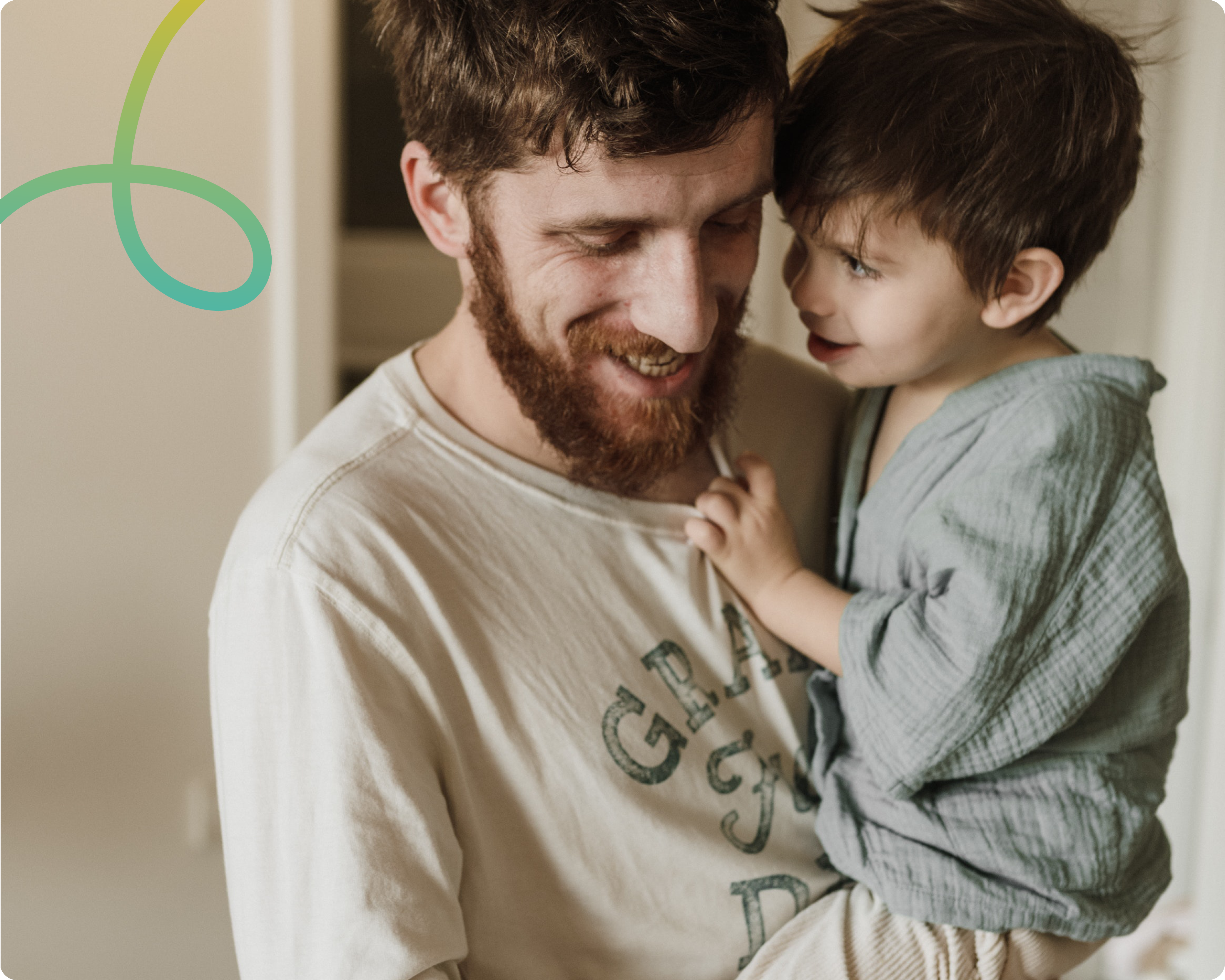 Image of a father holding his son and they are both smiling