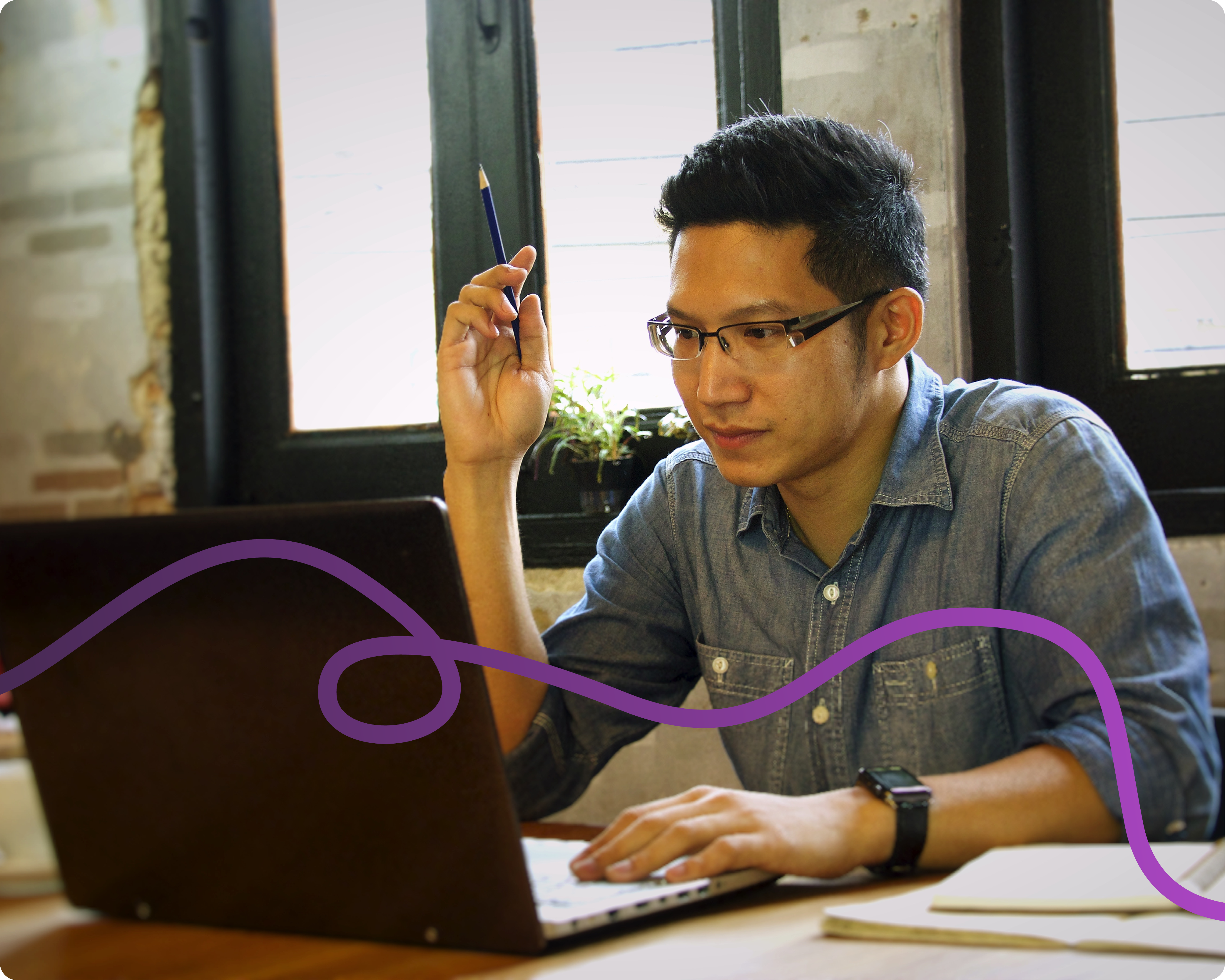 Image of a middle aged male sat at a desk on his laptop with a purple connecting line going through the image.