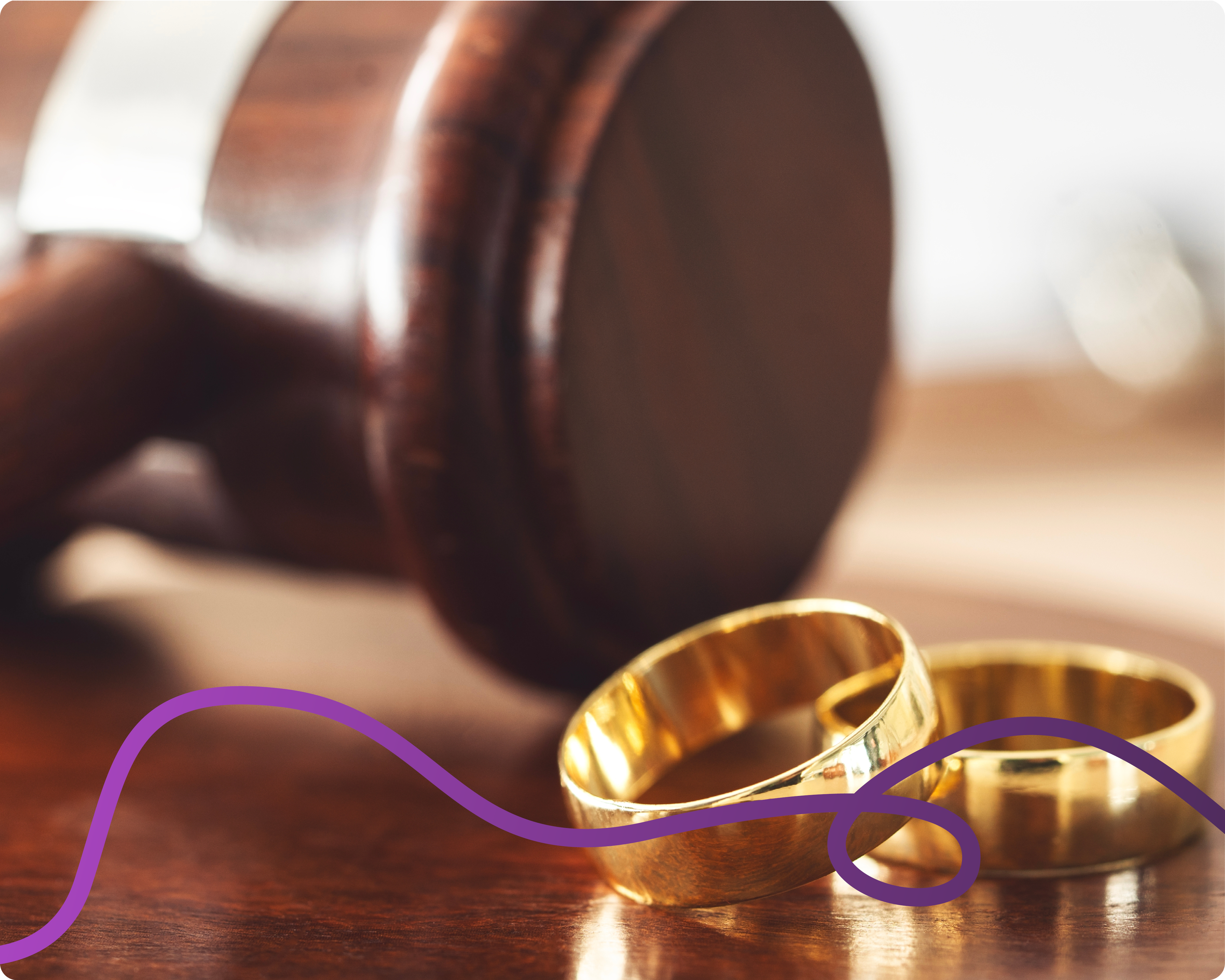 Image of two wedding rings and a gavel in the background.