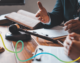 Close up of a gavel with two peoples hands having a discussion.