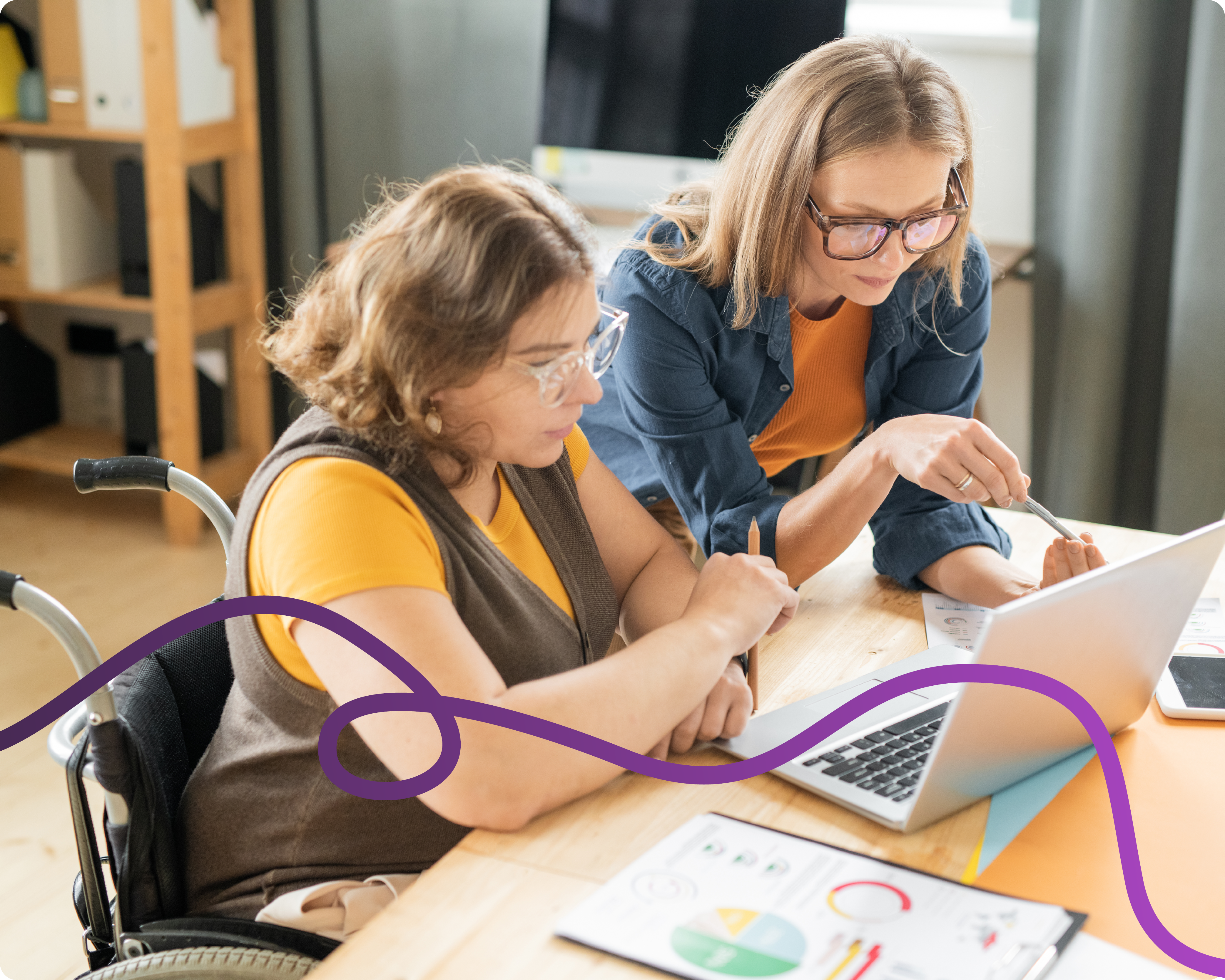 Image of a female wheelchair user and an older woman looking at a laptop