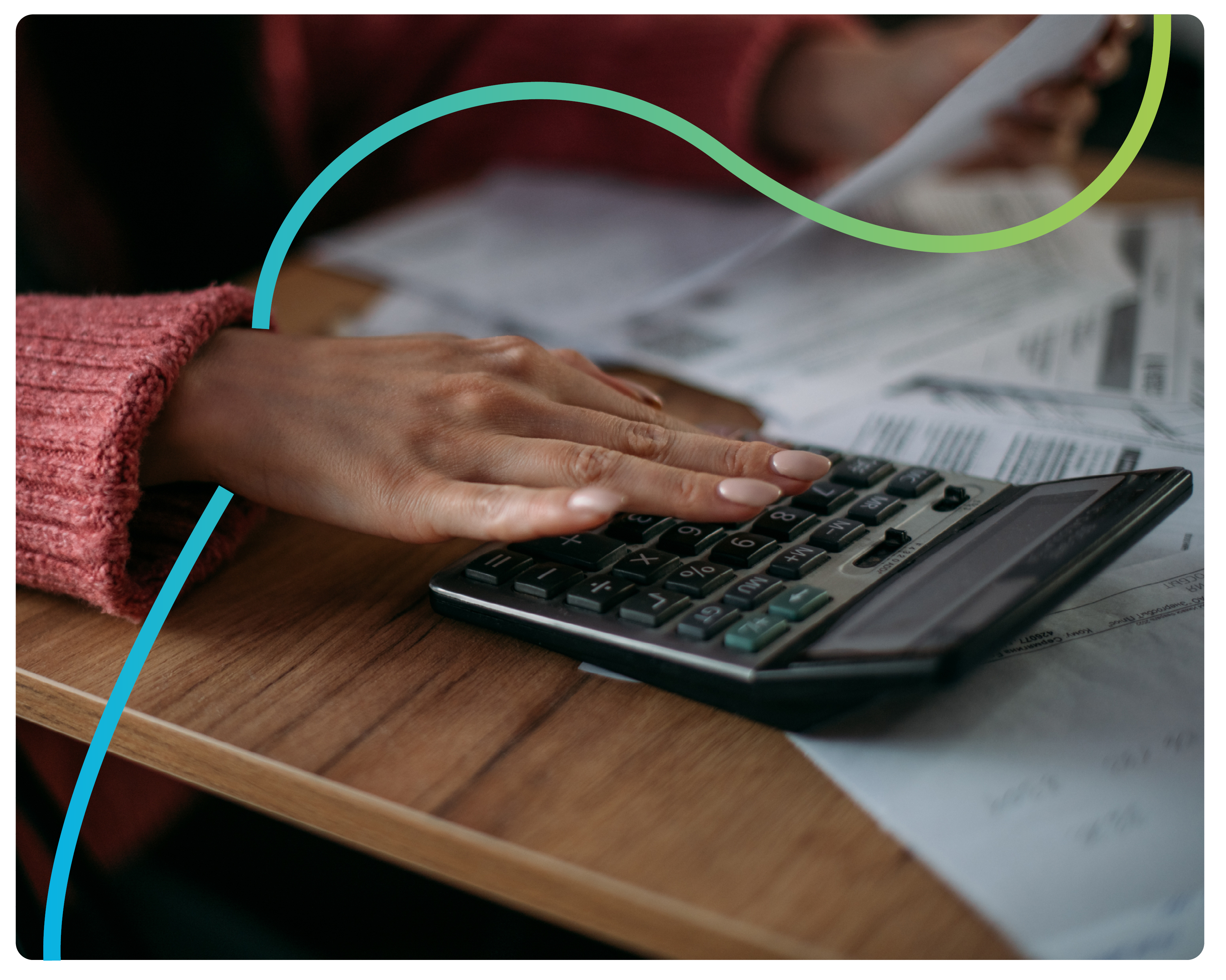 A close up of a womans' hand on a calculator whilst she calculates her bills