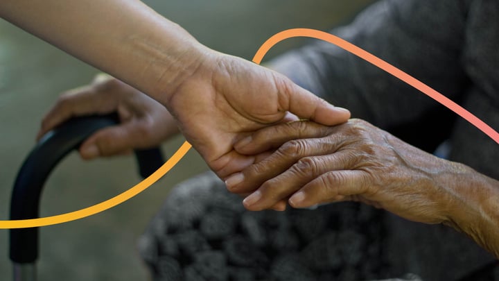 Elderly hand being held