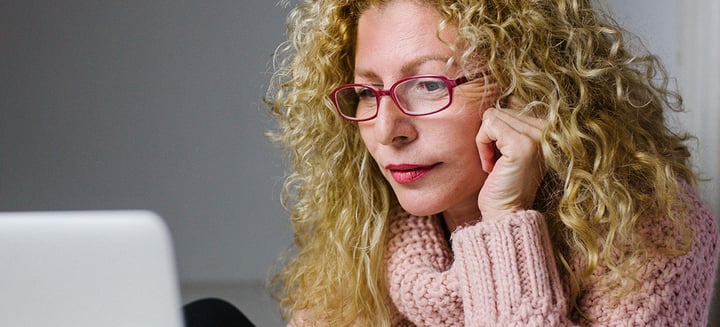 Natalie, age 54, concentrates on the laptop screen in front of her.