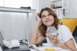 Smiling women holding a piggy bank