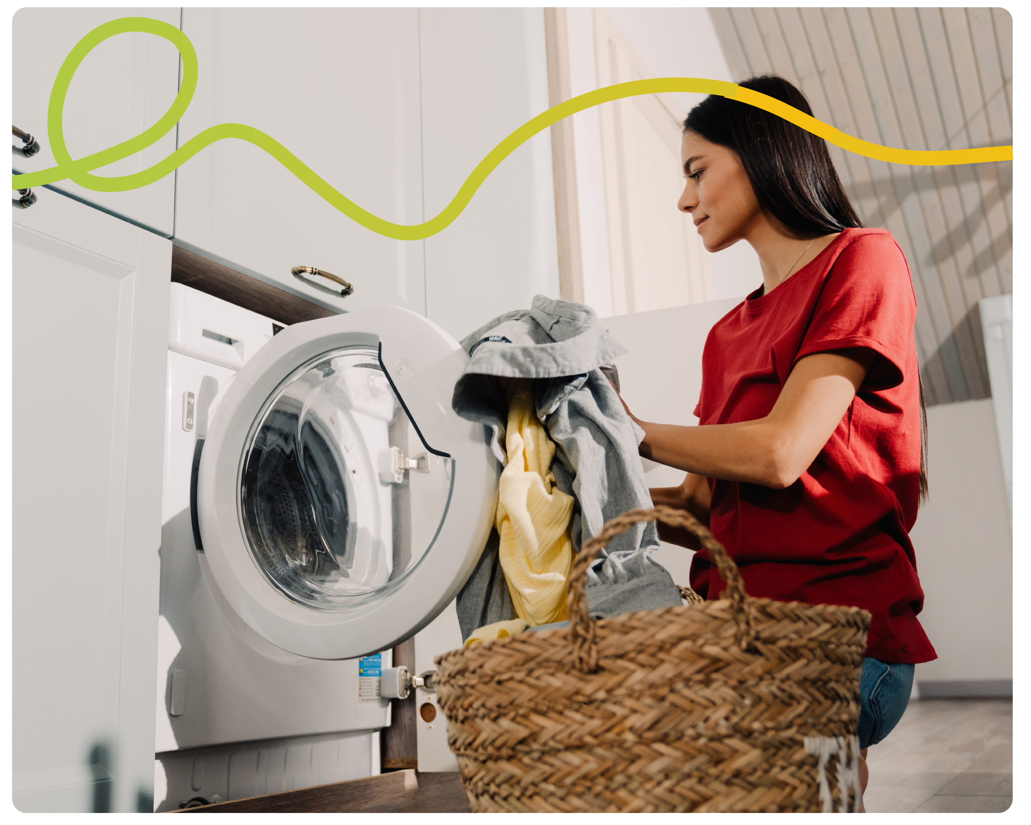 Woman crouched down loading clothes into her washing machine