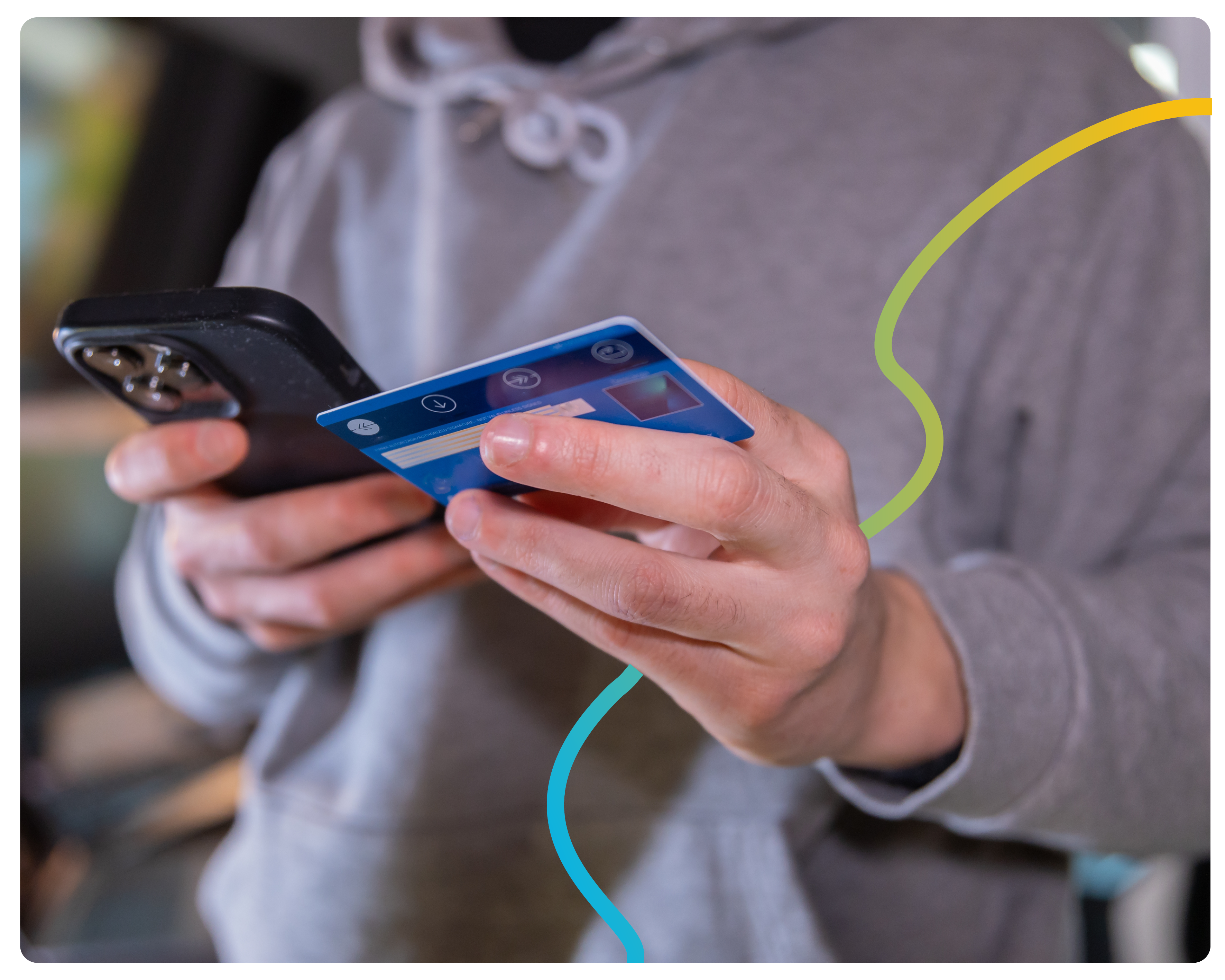 A close-up of a man entering his card details onto his phone