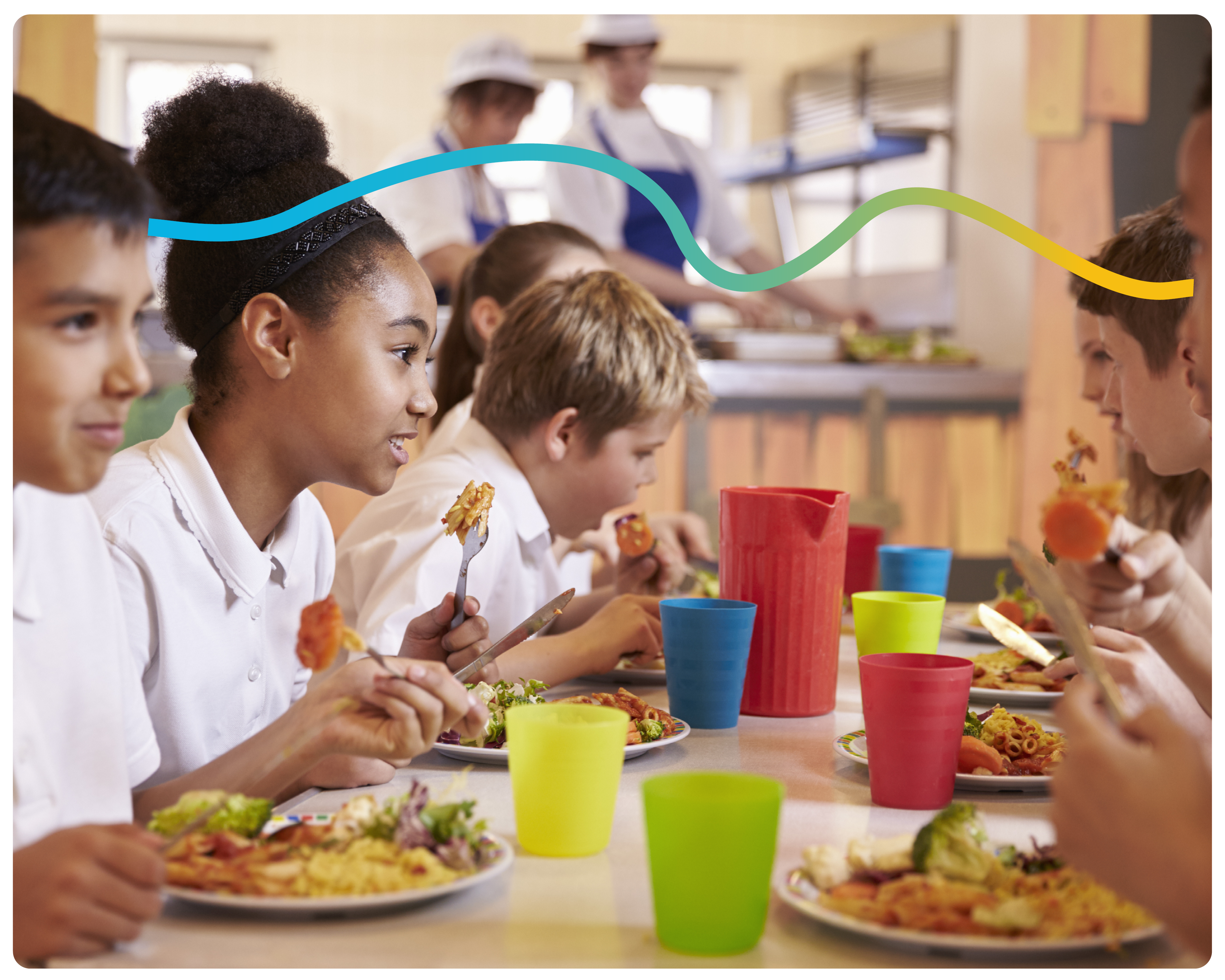 Primary school children sat in the lunch hall eating lunch