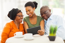 Three people sat around a laptop