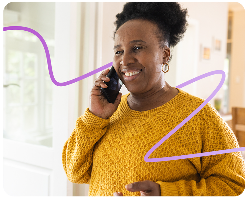 Happy senior african american woman talking on smartphone at home.
