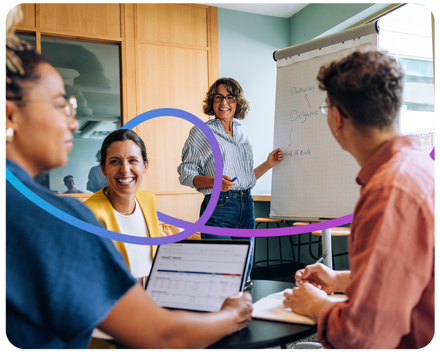 A diverse team gathered in a meeting, discussing strategies with a visual aid