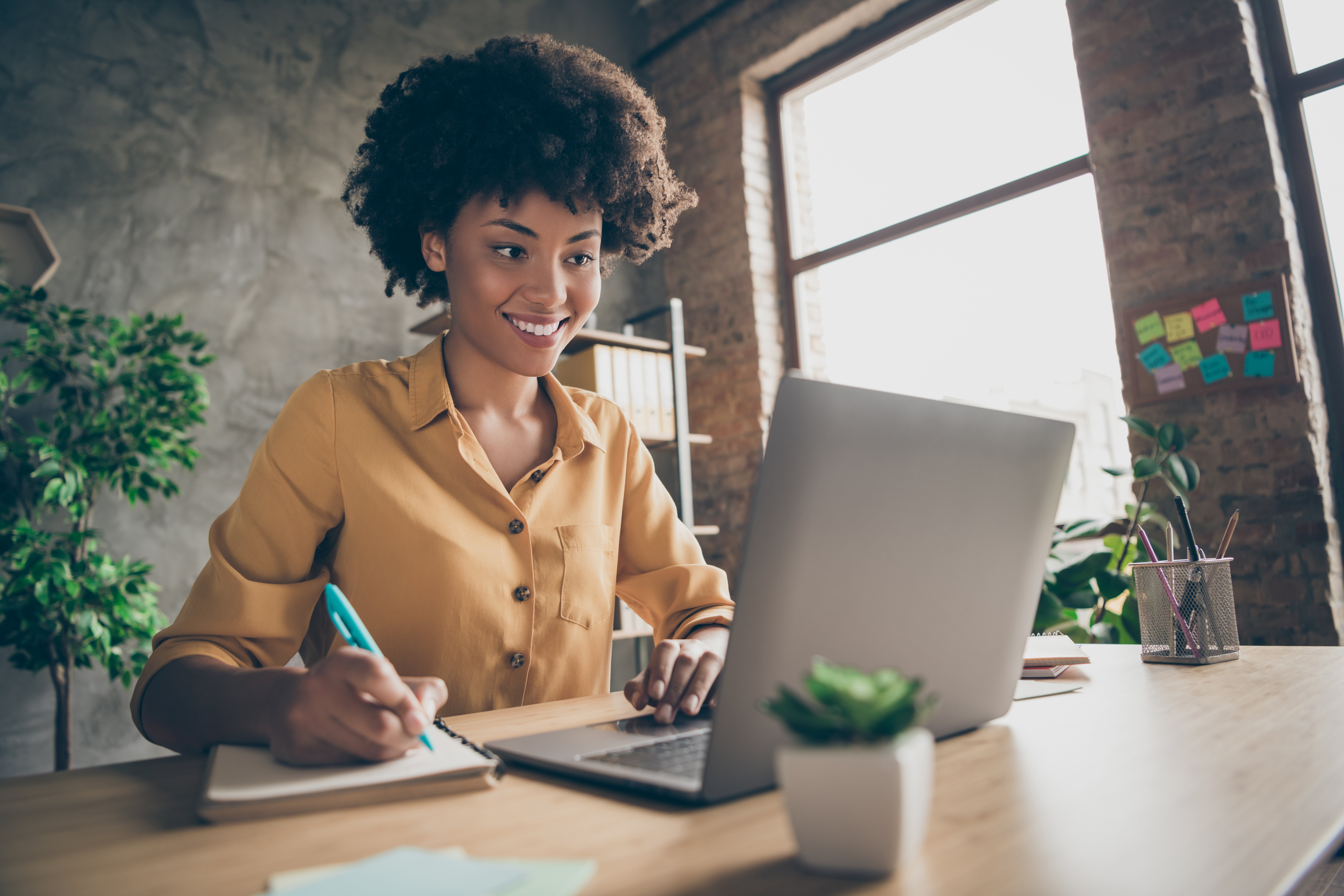 Smiling woman sitting at her desk with a laptop