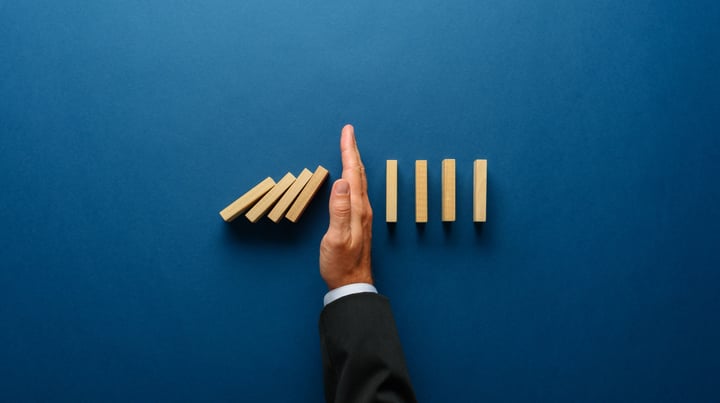 Exclusion shown by hand separating wooden blocks