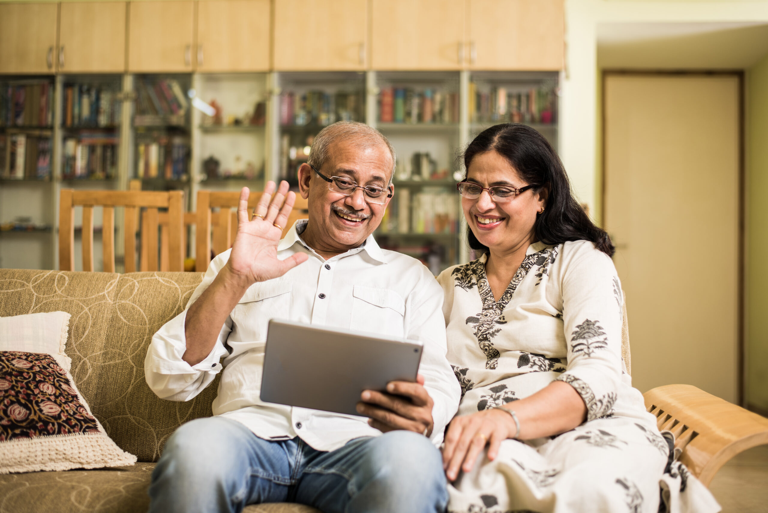 Two people sat on a sofa using a laptop