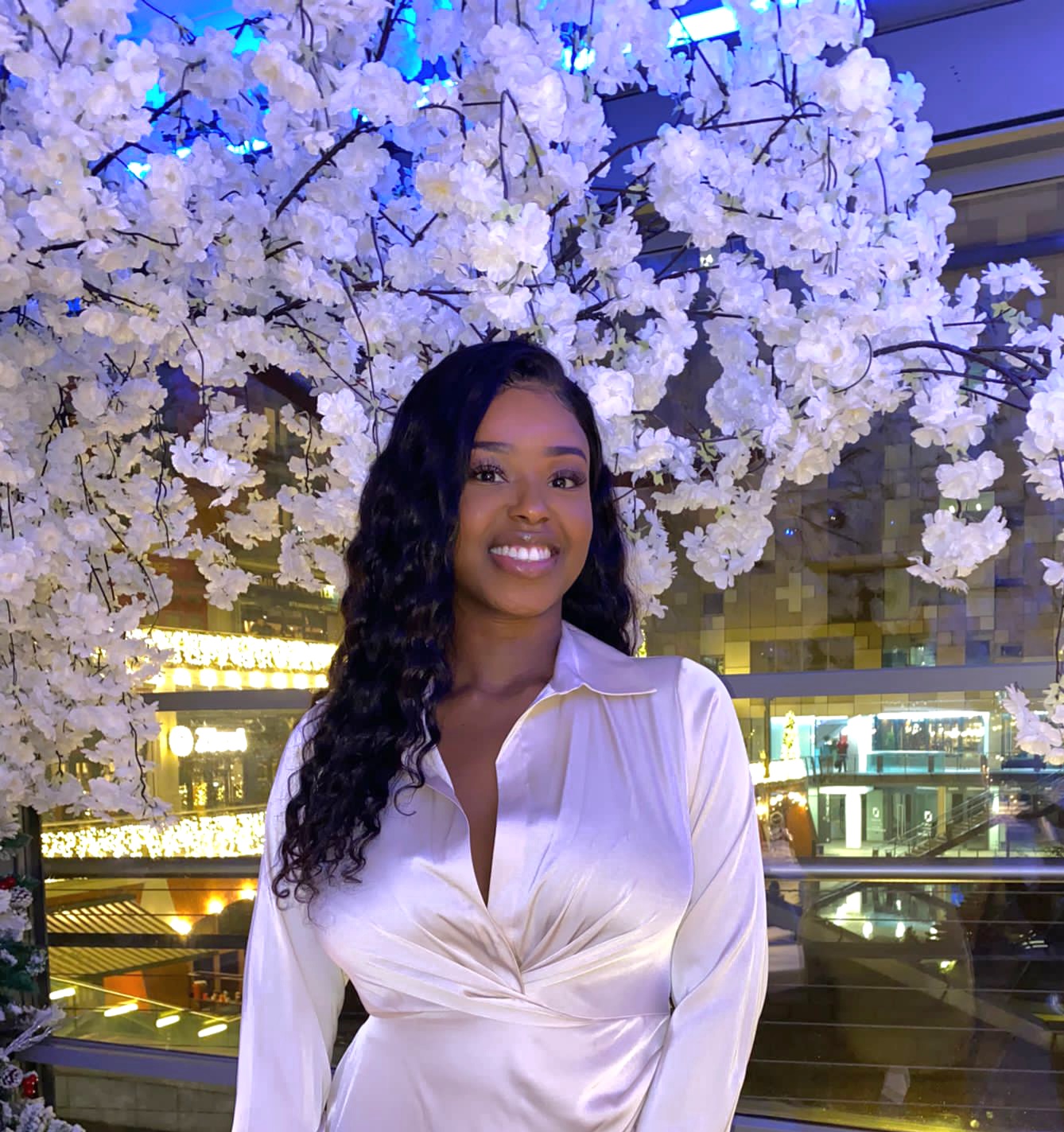 Image of a young woman smiling in a white dress