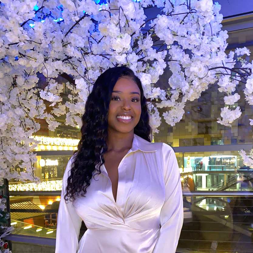 Image of a young woman smiling in a white dress