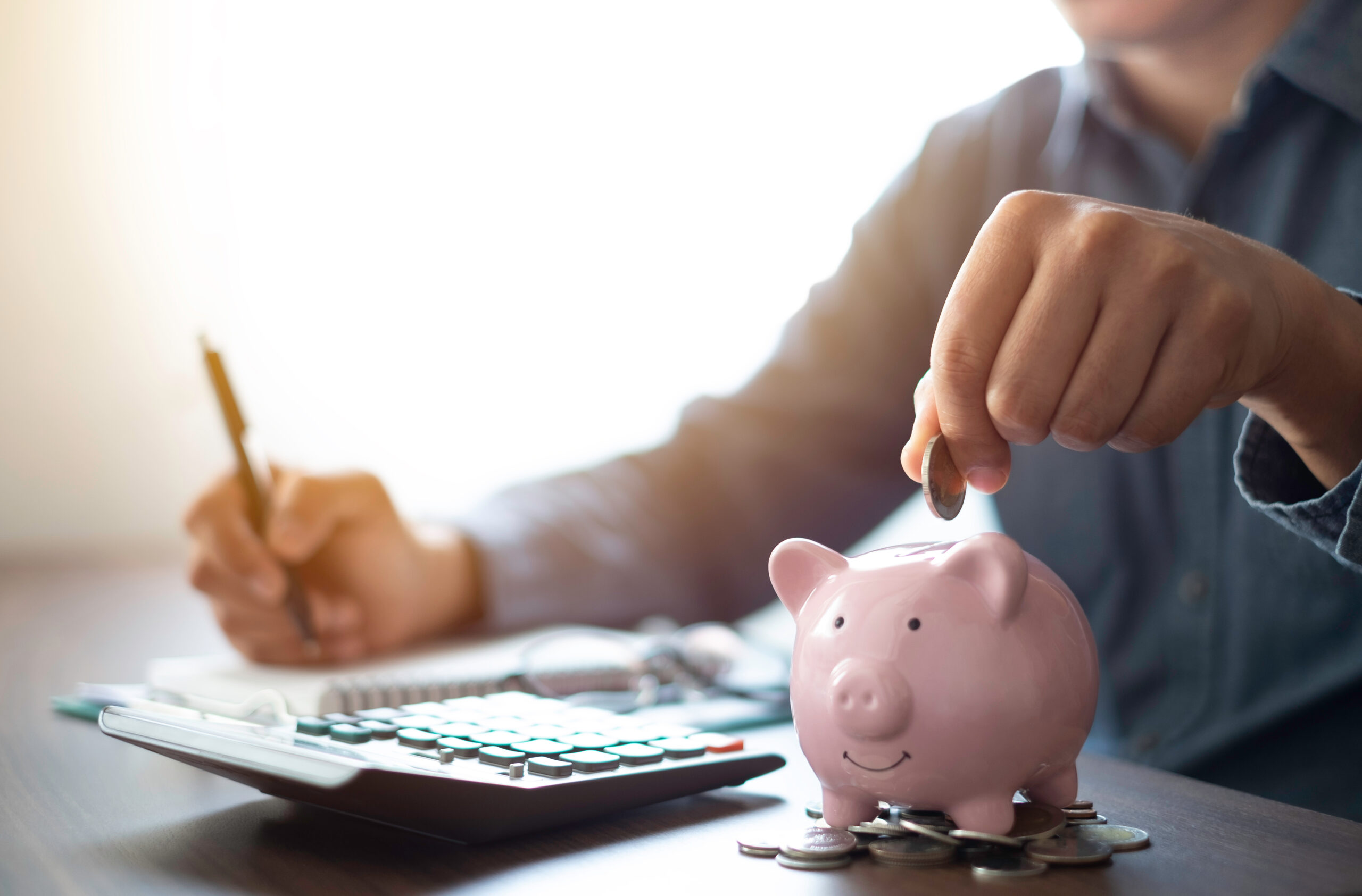 Man putting money in a piggy bank jar