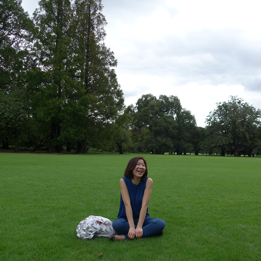 Image of a middle aged woman (Sandy) sitting on the ground smiling